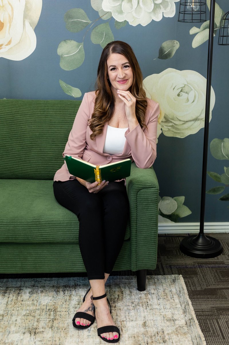 Trisha McWilliams with a green journal at Renewed Roots Counseling